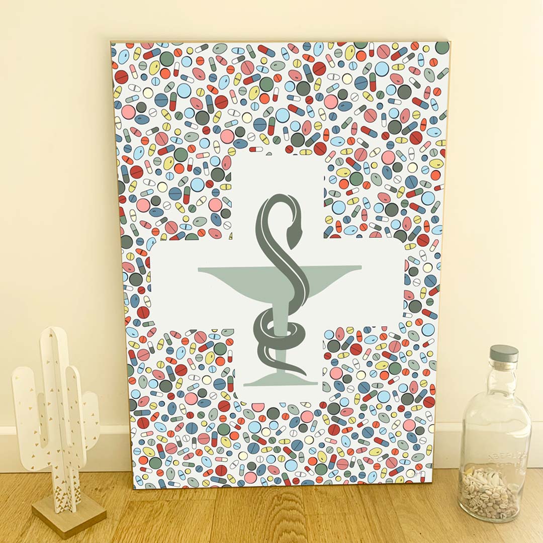 Affiche en bois Coupe d’Hygie 50 × 70 cm, fond blanc cassé et gélules multicolores, présentée en décoration murale.